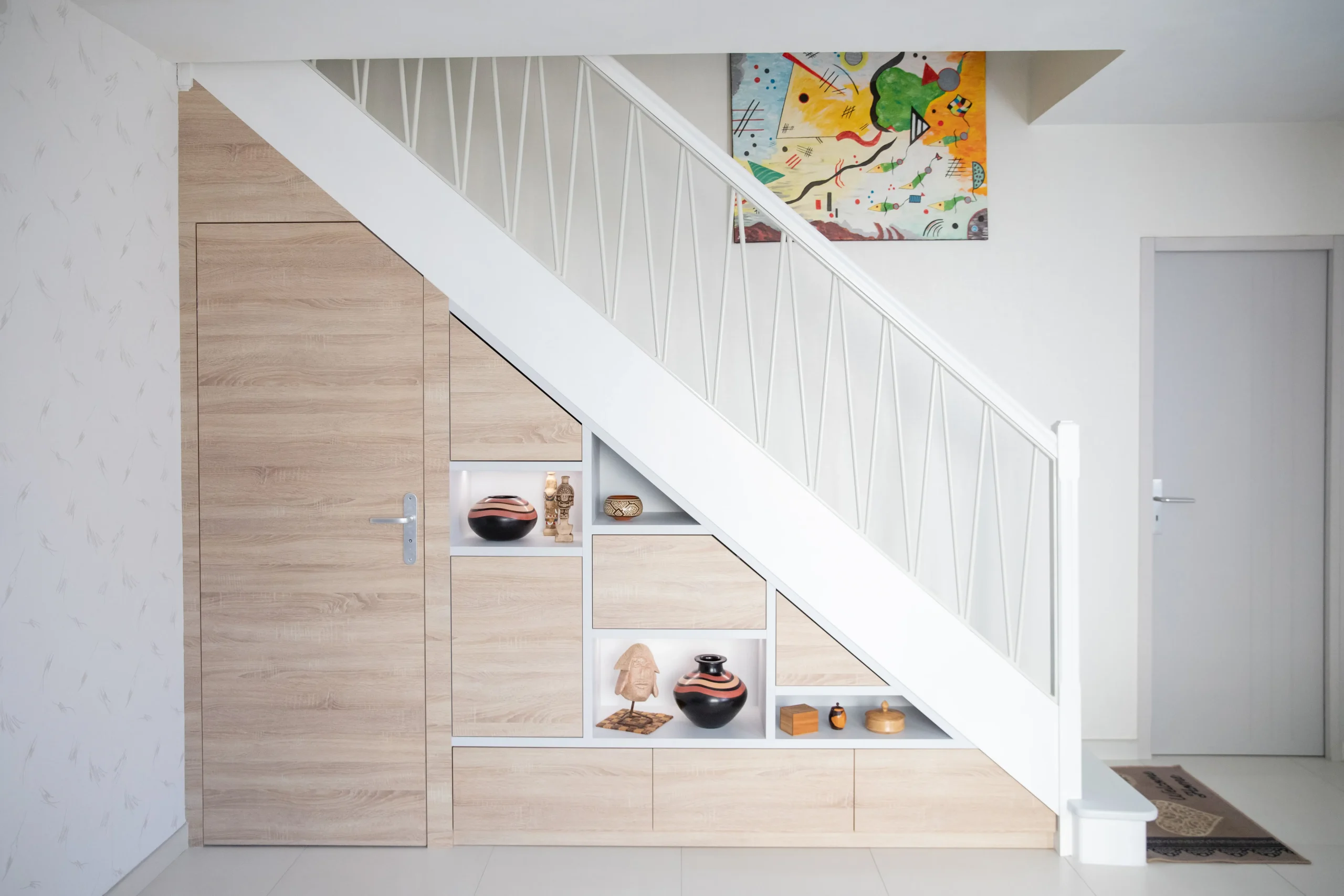 Meuble d'entrée sur mesure sous escalier avec espaces de rangement integrés