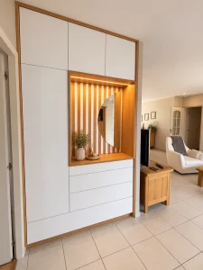 Meuble d’entrée sur-mesure blanc et bois avec niche éclairée et miroir arrondi